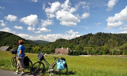 Zwei Räder sind am Straßenrand abgestellt und eine Frau blickt in die Landschaft