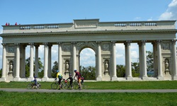 Eine Familie radelt auf einem Radweg in Prag an einem Viadukt vorbei