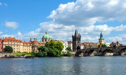 Blick über die Moldau auf Prag mit der steinernen Bogenbrücke