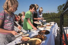 Gäste bedienen sich am reich gedeckten Barbecue an Deck der MS Princesse Royale