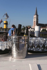 Drei Flaschen Champagner in einem Kühlgefäß, daneben ein Tablett mit Gläsern auf der MS Princesse Royale