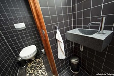 Blick in die für alle Gäste öffentliche schwarz geflieste Toilette auf der MS Princesse Royale