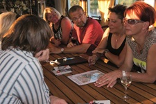 Gäste sitzen an einem Tisch auf der MS Princesse Royale und besprechen die nächste Rad-Tour mit dem Guide