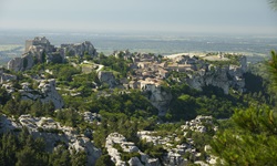 Panoramablick auf die harmonisch in die umgebenden Felsen eingebaute Stadt Les Baux-de-Provence und die Ruinen der einstigen Festung.
