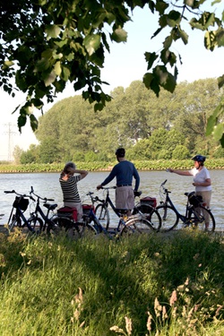 Drei Radfahrer machen pause an einem Fluss in Holland