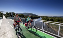 Ein Radlerpärchen überquert auf der Freiheitsbrücke bei Bratislava die Donau.