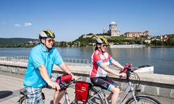 Zwei Radler fahren am Donauufer bei Esztergom entlang.