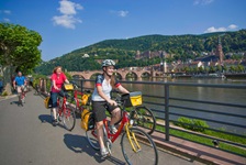 Drei Radler am Neckarufer bei Heidelberg.