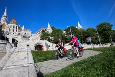 Drei Radler fahren an der Fischerbastei und der Matthiaskirche in Budapest vorbei.