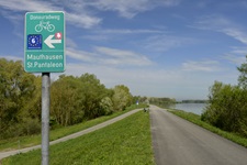 Eines der typischen grünen Schilder, die den Donauradweg in Österreich markieren.