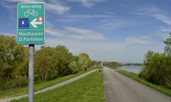 Eines der typischen grünen Schilder, die den Donauradweg in Österreich markieren.