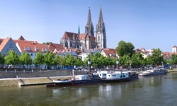Blick über die Donau mit angelegten Schiffen bis zum Dom St. Peter mit seinen beiden Türmen in Regensburg