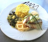 Appetitlich angerichtete Hauptspeise mit gebratenem Fleisch, Reis und Zucchinigemüse.