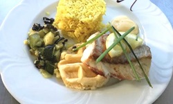 Appetitlich angerichtete Hauptspeise mit gebratenem Fleisch, Reis und Zucchinigemüse.
