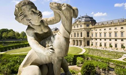 Die Steinstatue Kind mit Hund im Garten der Residenz von Würzburg.