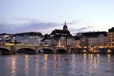 Blick auf eine Brücke über den Rhein zu einer Stadt in der Abenddämmerung