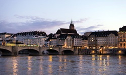 Blick auf eine Brücke über den Rhein zu einer Stadt in der Abenddämmerung