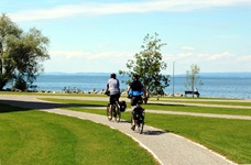 Zwei Radfahrer radeln am Bodensee entlang des Rhein-Radwegs
