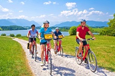 Vier Radler auf einem weiß gekiesten Radweg am Riegsee.