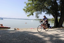 Ein Fahrradfahrer fährt am Ufer des Ammersees entlang