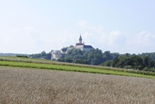 Blick über Wiesen und Felder zum Kloster Andechs