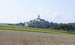 Blick über Wiesen und Felder zum Kloster Andechs