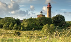 Der neue und der alte (auch Schinkelturm genannte) Leuchtturm von Kap Arkona auf Rügen werden idyllisch von Bäumen eingerahmt.
