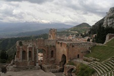 Die Ruinen des antiken Theaters von Taormina, im Hintergrund der schneebedeckte Ätna.