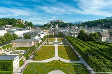 Wunderschöne Stadtansicht von Salzburg mit der gleichnamigen Festung und dem Dom im Hinter- sowie dem prächtig bepflanzten Mirabellgarten im Vordergrund.
