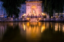 Blick auf den nächtlich beleuchteten Brunnen auf dem Residenzplatz in Salzburg