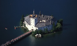 Luftbild des Seeschlosses Ort(h) im Traunsee mit Bootshaus auf der rechten Seite und dem Schiffsteg