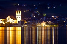 Das nächtlich beleuchtete St. Wolfgang mit der Pfarr- und Wallfahrtskirche sowie dem Weißen Rössel