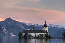 Das inmitten des Traunsees gelegene Schloss Orth im ersten Abendlicht.