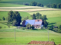 Ein mit Solarpaneelen bestücktes, inmitten grüner Wiesen gelegenes Schwarzwaldhaus im Weiler Thurner.