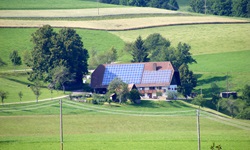Ein mit Solarpaneelen bestücktes, inmitten grüner Wiesen gelegenes Schwarzwaldhaus im Weiler Thurner.