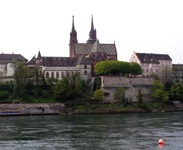 Die Basler Altstadt mit dem bunt gedeckten Roten Münster, im Vordergrund der Rhein.