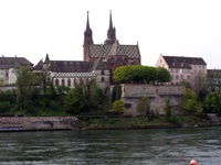 Die Basler Altstadt mit dem bunt gedeckten Roten Münster, im Vordergrund der Rhein.