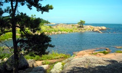 Traumhafter Ausblick auf eine malerische, von sattgrünem Gras umgebene Bucht in Südschweden.