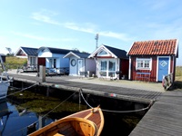 Fünf kleine Bootshäuser an einem Hafen in Schweden