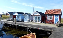 Fünf kleine Bootshäuser an einem Hafen in Schweden