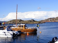 Ein Fischerboot aus Holz mit schwedischer Flagge an einem schwedischen Hafen