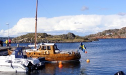 Ein Fischerboot aus Holz mit schwedischer Flagge an einem schwedischen Hafen