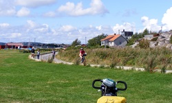 Ein Radler fährt auf einer Straße an einem schwedischen Dorf vorbei