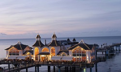 Blick auf die abendlich beleuchtete Seebrücke von Sellin mit Restaurant