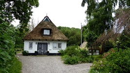 Frontalansicht auf ein Fachwerkhaus mit braun-weiß gestrichener Holztür im Örtchen Sieseby