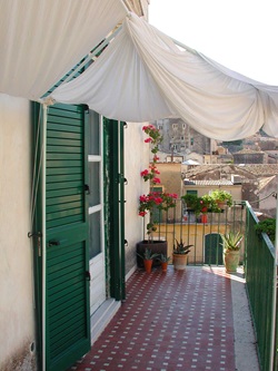 Idyllischer kleiner Balkon mit Blumenschmuck in Modica.