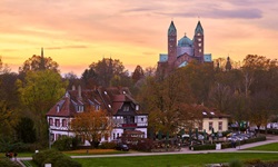 Sonnenuntergang über dem Dom von Speyer und dem am Rheinufer gelegenen Restaurant Alter Hammer.