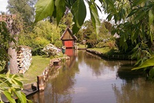 Blick auf eine der vielen Wasserstraßen mit Bootshaus im Spreewald