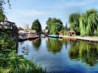 Blick über die Spree zu einem kleinen Hafen mit Ausflugsbooten