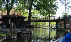 Eine Holzbrücke im Spreewald führt über einen Flussarm der Spree.